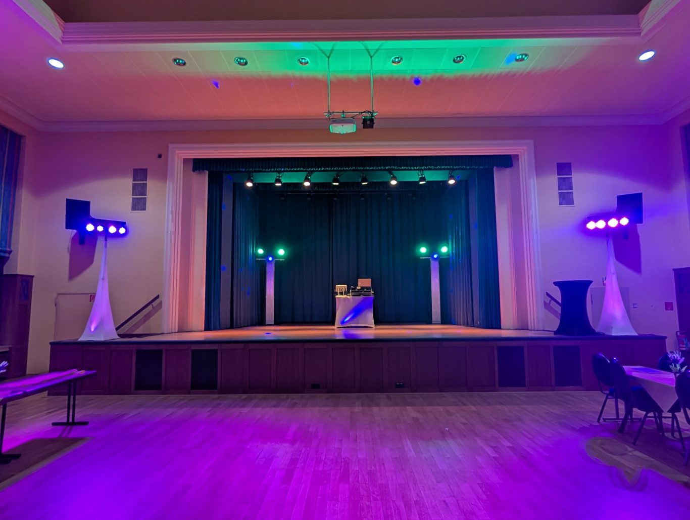 Jubiläum 40 Jahre VAKS in der Weißtalhalle Siegen Bühne mit bunt beleuchtetem Podest und zwei Lichtständern, im Hintergrund schwarzer Vorhang.