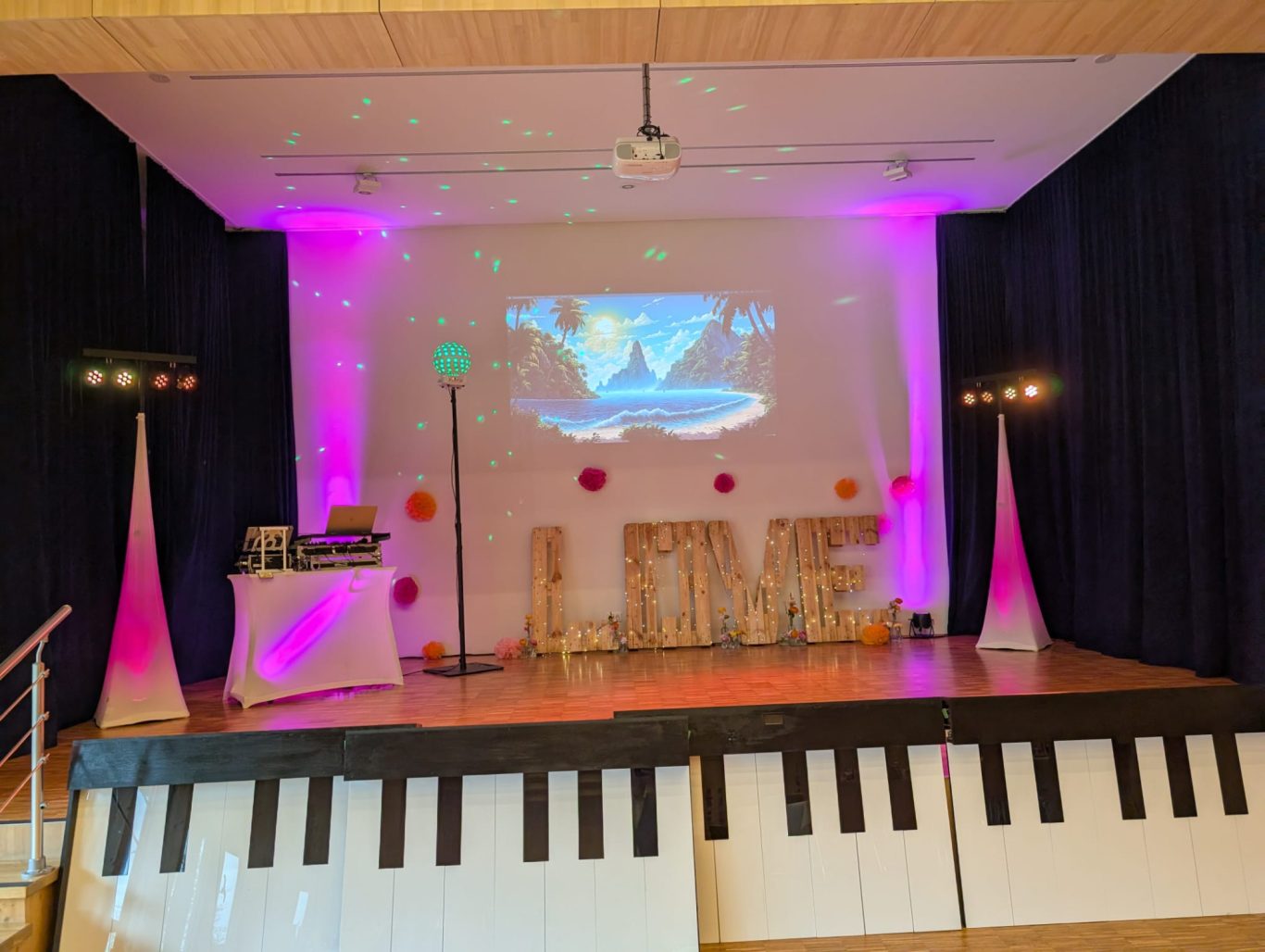 Hochzeitsfeier im Bürgerhaus Herborn Burg Bühne mit Pianotastatur, DJ-Ausrüstung und bunten Lichtakzenten für eine Veranstaltung.